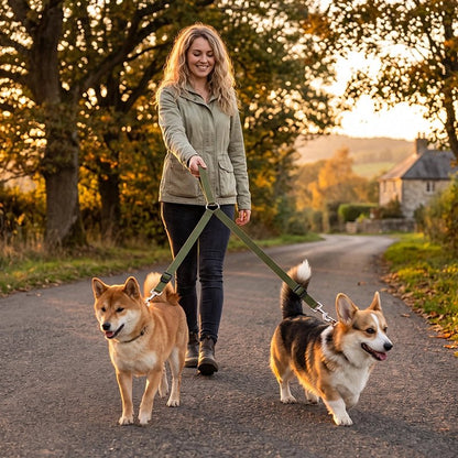 Accouple chien​ femme dans un parc avec ses deux chiens profitant de la laisse double 