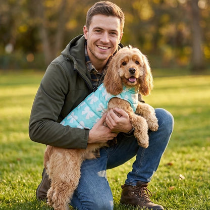 Manteau pour Chien caniche dans les bras de son maitre avec son manteau bleu