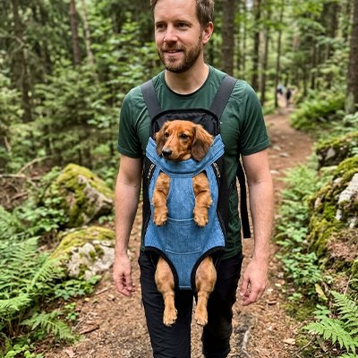 Sac de transport Chien homme portant son teckel dans la foret dans son sac de transport